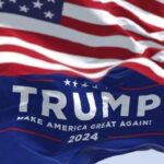 American flag and Trump 2024 campaign flag waving