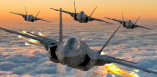 Four fighter jets flying above clouds, firing flares.