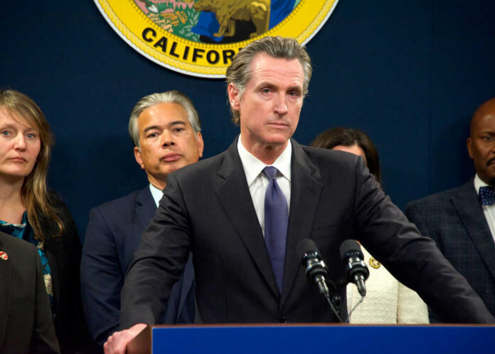Person speaks at podium with California seal behind.