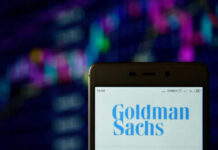 Phone displaying Goldman Sachs logo in front of chart