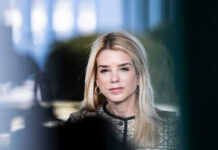 DOJ Pulls Epstein Files—What’s Hiding? Woman with long blonde hair wearing hoop earrings