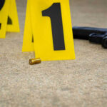 Crime scene with evidence markers gun and bullet casings