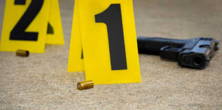 Crime scene with evidence markers gun and bullet casings