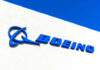 Boeing logo on a white building, blue sky.