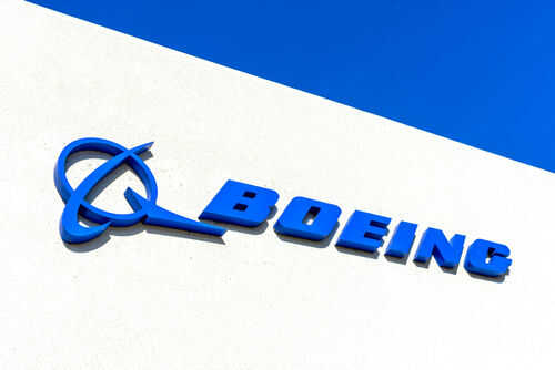 1867009000 Boeing logo on a white building, blue sky.