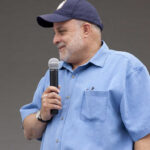 Man speaking into a microphone at an outdoor event