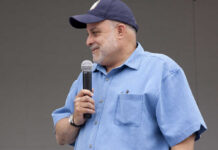 Man speaking into a microphone at an outdoor event