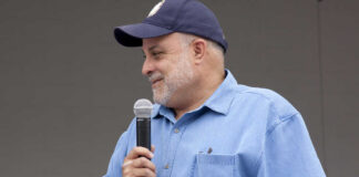 Man speaking into a microphone at an outdoor event