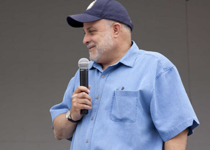 Man speaking into a microphone at an outdoor event