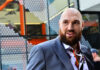 Man with a beard wearing a colorful shirt and a suit in an urban environment