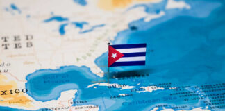 A small Cuban flag placed on a map highlighting Cuba in the Caribbean