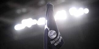 Tottenham Hotspur corner flag illuminated by stadium lights