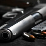 Close-up of a handgun and ammunition on a dark background