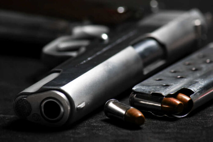 Close-up of a handgun and ammunition on a dark background