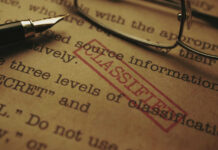 SHOCK Espionage Scandal: Iran Buys IDF Intel Close-up of a classified document with a pen and glasses