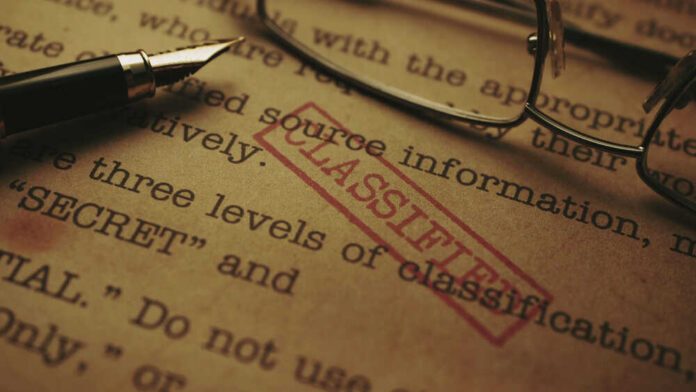 Close-up of a classified document with a pen and glasses