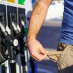Person showing empty pockets at a gas station