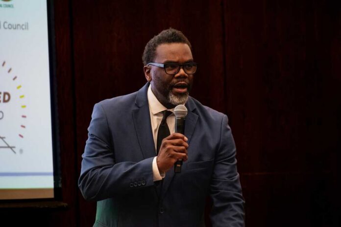 A man in a suit speaking into a microphone at a conference