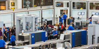 Airport security checkpoint with travelers and TSA agents