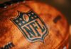 Close-up of an NFL football with the logo and stitching visible