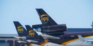 Three UPS cargo planes parked at an airport with visible tails