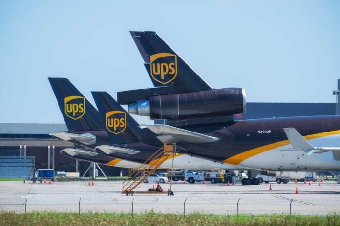 Three UPS cargo planes parked at an airport with visible tails
