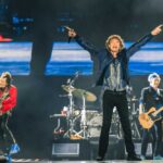 Rock band performing on stage with vibrant lights