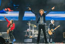 Rock band performing on stage with vibrant lights