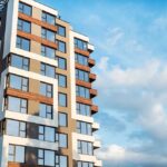 Modern residential building with large windows against a blue sky