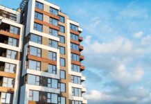 Modern residential building with large windows against a blue sky