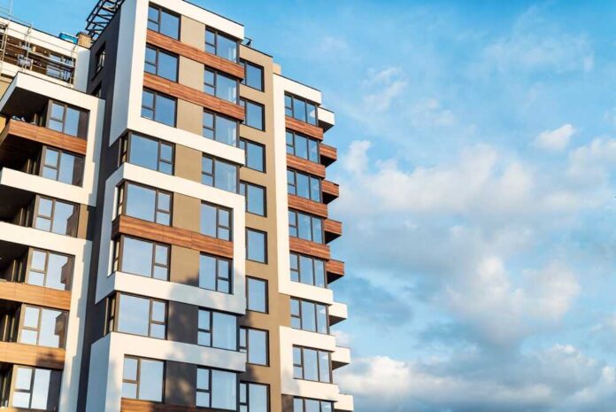 Modern residential building with large windows against a blue sky