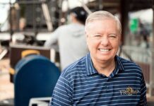 Smiling man in a striped shirt at an outdoor event