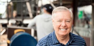 Smiling man in a striped shirt at an outdoor event