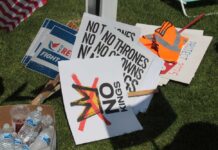 A collection of protest signs and water bottles on grass