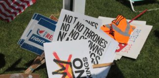 A collection of protest signs and water bottles on grass