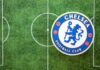 Chelsea Football Club logo on a soccer field background