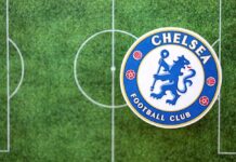 Chelsea Football Club logo on a soccer field background