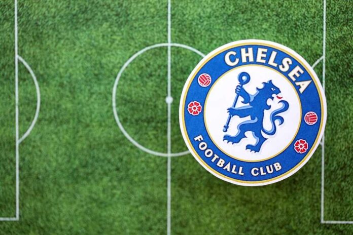 shutterstock_2685636955.jpg Chelsea Football Club logo on a soccer field background