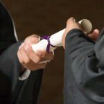 Fraudulent Diplomas: California Schools Caught in Scandal Two individuals exchanging a diploma during a graduation ceremony