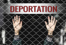 Hands reaching through a chain-link fence with the word 'DEPORTATION' above