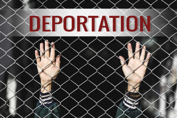Hands reaching through a chain-link fence with the word 'DEPORTATION' above