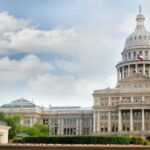 Capitol building with dome and Texas flag displayed