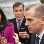 People talking outside with microphones and phone visible