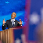 Man speaking at podium with blue starry background