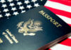 An American passport resting on a background of the U.S. flag