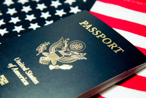 An American passport resting on a background of the U.S. flag