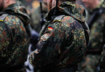 Close-up of soldiers in camouflage uniforms with German flags