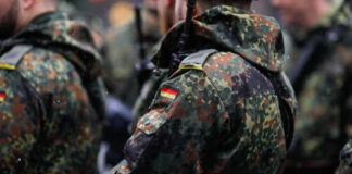 Close-up of soldiers in camouflage uniforms with German flags