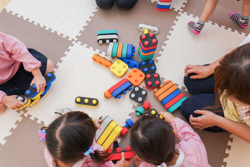 Children playing with colorful educational toys on a mat