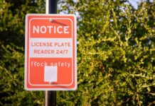 Notice sign indicating a 24/7 license plate reader for safety